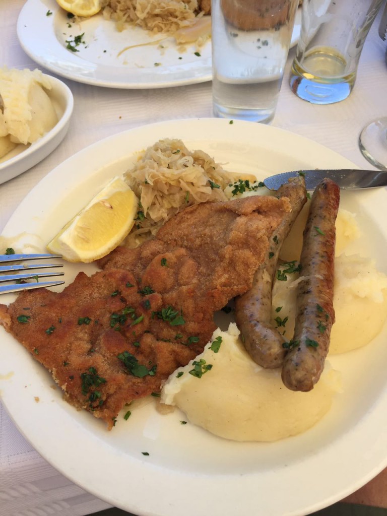 Schnitzel with potato mash, bangers and sauerkraut.